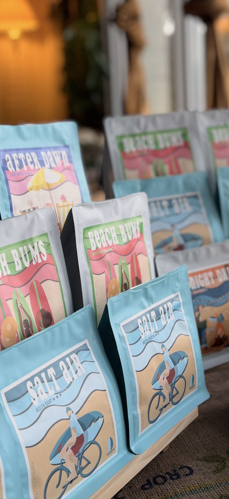 Shelf of Sands Coffee bags in blue and white with illustrated labels